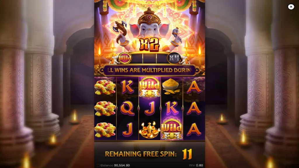 Ganesha Gold free spins round with x2 multiplier and reels showing wilds, flowers, and golden powder symbols.