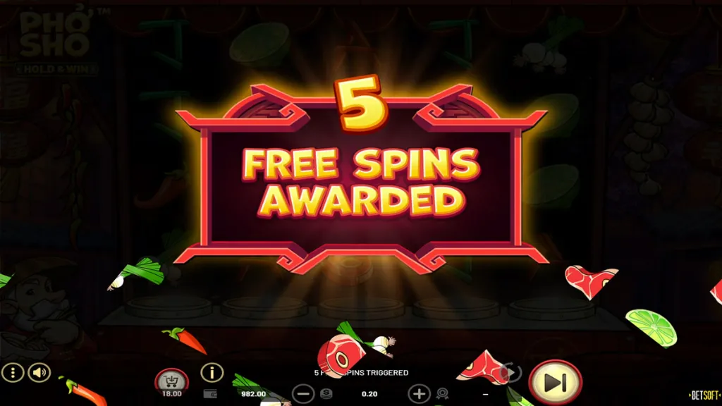 Bonus activation screen in Pho Sho. A glowing red banner in the center announces “5 FREE SPINS AWARDED,” with ingredients like meat slices, chili peppers, and garlic falling across the reels.